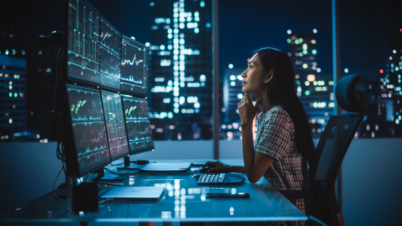 Portrait of a business woman Working on a Computer with Multi-Monitor Workstation